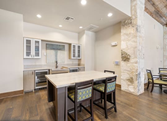 a kitchen with a large island with four chairs in front of it at Lakeline East Apartments, Cedar Park, TX