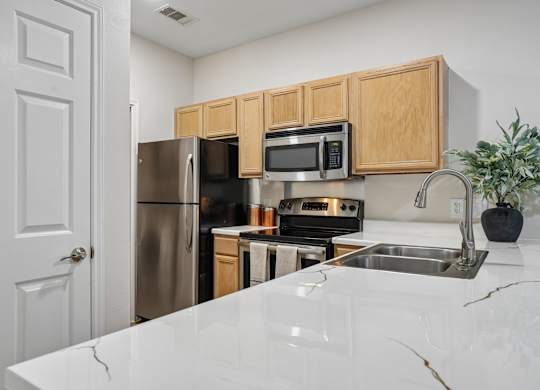 A kitchen with a white counter top and wooden cabinets.