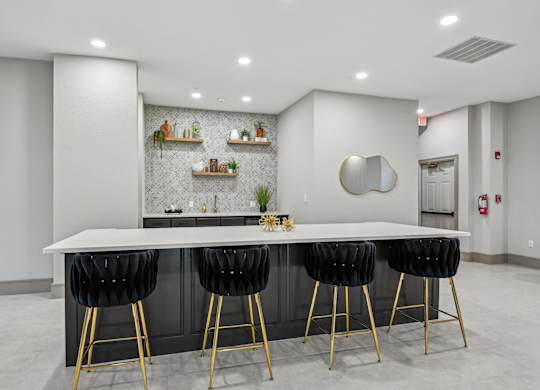 A modern kitchen with a white countertop and black bar stools.