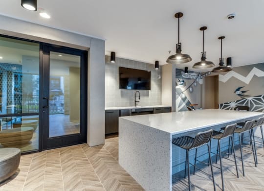 a kitchen with a large white counter top and a long white island with a bunch of chairs at Aurora Watson Branch, Texas
