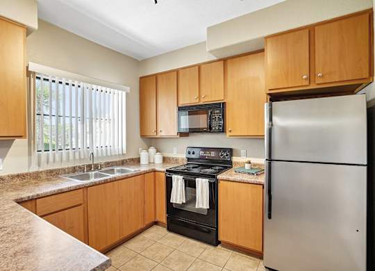 A kitchen with a stove, microwave, and refrigerator.