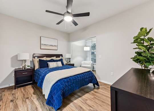 A bedroom with a bed, nightstand, and a ceiling fan. at Stone Oak @ Parmer, Austin, 78727