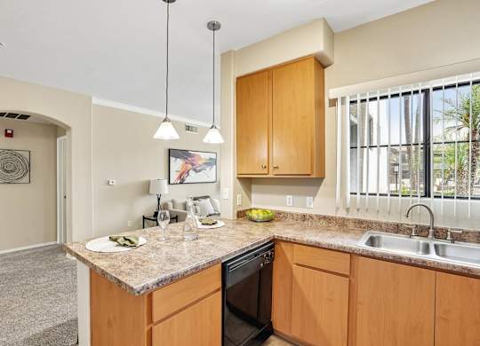 A kitchen with a sink, stove, and cabinets.