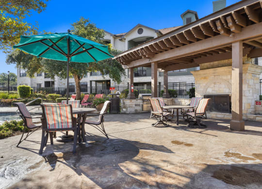 a patio with tables and chairs and umbrellas at The Fairways at Star Ranch, Hutto, Texas