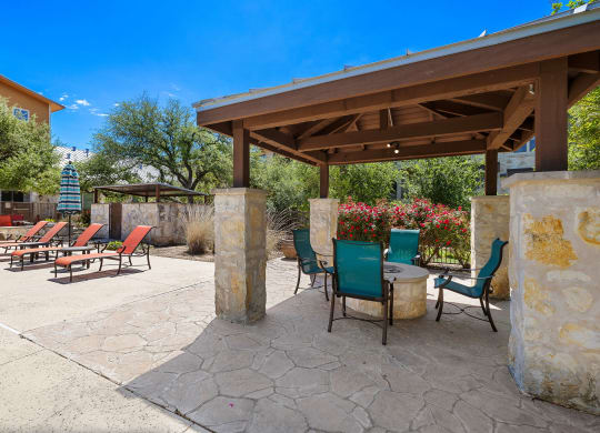 a patio with a table and chairs under a pavilion at Lakeline East Apartments, Cedar Park