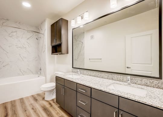 a bathroom with a large mirror and a shower and a toilet at Aurora Watson Branch, Mansfield, Texas