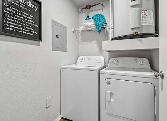 A white dryer and washer in a small laundry room.