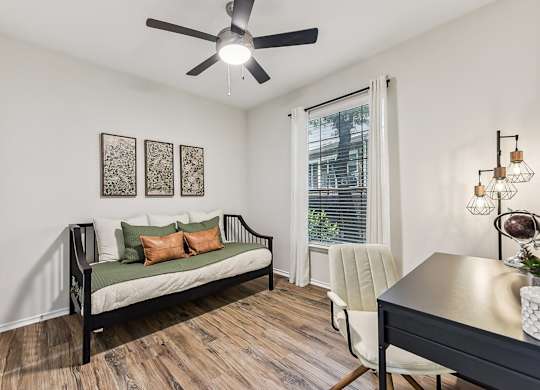 A room with a ceiling fan, a sofa, a chair, and a table at Stone Oak @ Parmer, Austin.