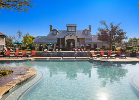 a large pool with chairs and a house in the background at The Fairways at Star Ranch, Hutto