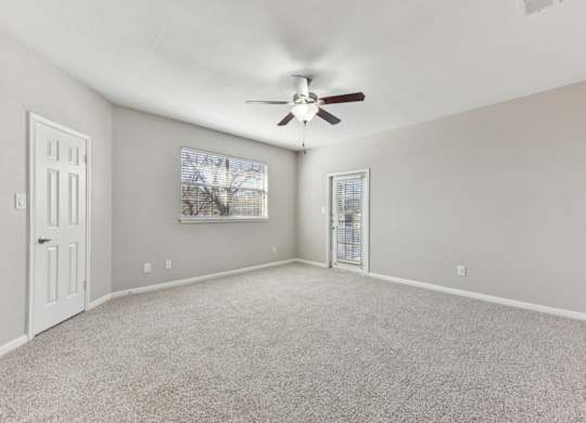 A room with a ceiling fan and carpeted floor. at Sonterra Apartment Homes, Texas