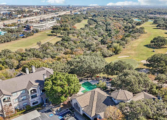 A bird's eye view of a residential area with houses and a swimming pool at TalaVera Apartments, San Antonio, Texas