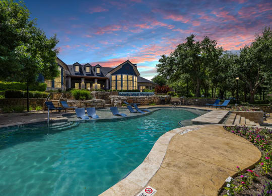 a swimming pool with a house in the background at sunset at The Vista on Brodie, Texas, 78745
