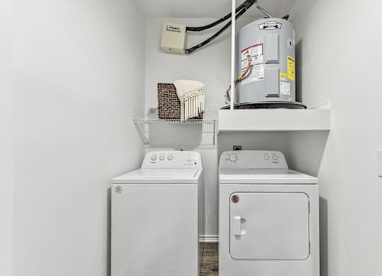 A white washing machine and dryer in a small laundry room. at Stone Oak @ Parmer, Austin, Texas