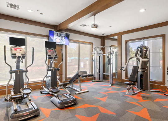 a home gym with exercise equipment and windows at Lakeline East Apartments, Cedar Park, 78613