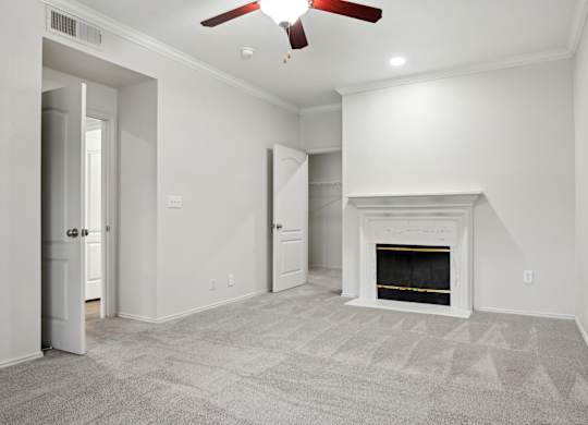 A room with a fireplace and a ceiling fan.