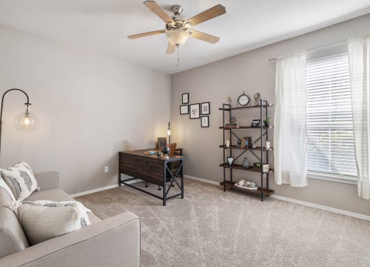 a living room with a couch and a ceiling fan at Sonterra Apartment Homes, Texas