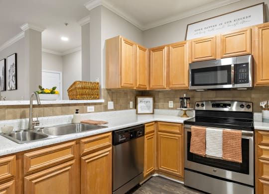 a kitchen with wooden cabinets and stainless steel appliances at The Verandah, Austin, 78726
