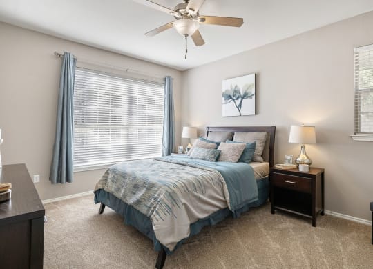 a bedroom with a bed and a ceiling fan at Sonterra Apartment Homes, Austin