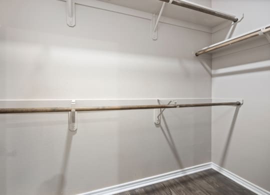 A spacious walk in closet in a bedroom with white walls at Waters Edge Apartment Homes, Georgetown, Texas
