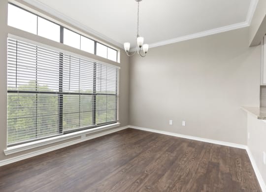 An empty living room with a large window at Waters Edge Apartment Homes, Georgetown, Texas