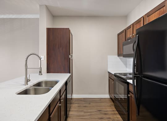 an empty kitchen with black appliances and a white counter top at The Fairways at Star Ranch, Texas