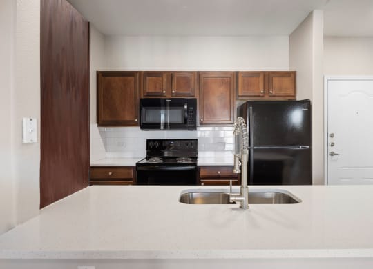 a kitchen with a white counter top and a black refrigerator at The Fairways at Star Ranch, Hutto, Texas