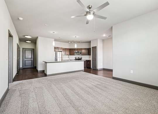 A spacious living room with a carpeted floor and a ceiling fan.at North Creek, Texas, 78634