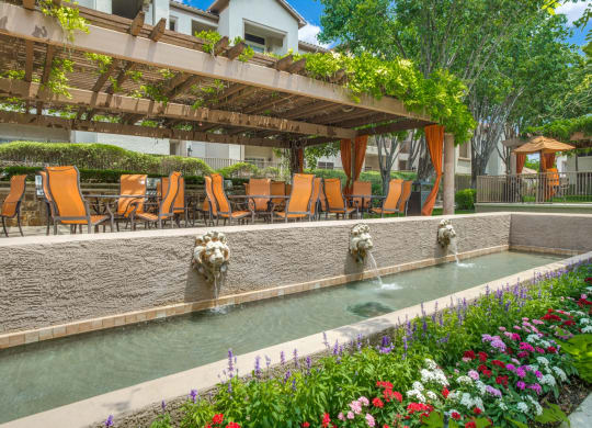 a swimming pool with chairs and water fountains at La Ventura Apartments, Plano, 75093