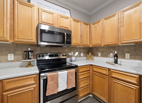 a kitchen with stainless steel appliances and wooden cabinets at The Verandah, Texas, 78726