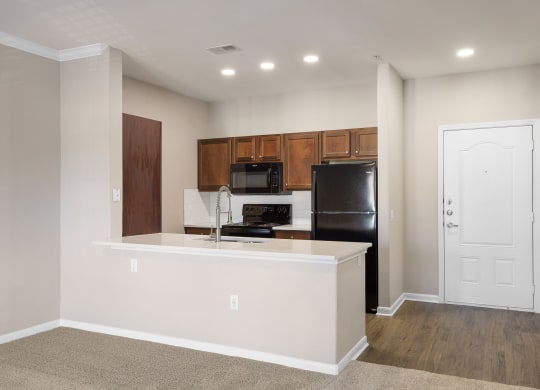 a kitchen with a large island and a black refrigerator at The Fairways at Star Ranch, Hutto, Texas