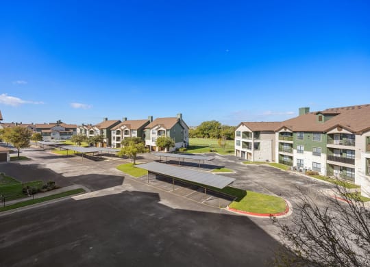 an aerial view of an empty parking lot with houses in the background at The Fairways at Star Ranch, Hutto, TX, 78634