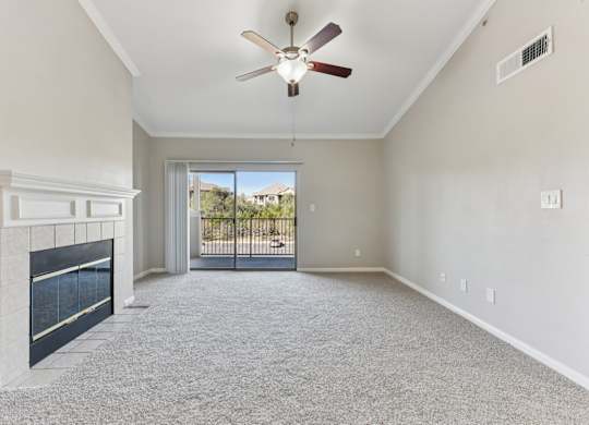 A spacious room with a fireplace and a ceiling fan. at Sonterra Apartment Homes, Austin, Texas