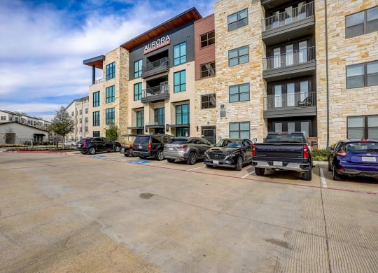 a parking lot with cars in front of an apartment building at Aurora Watson Branch, Texas, 76063