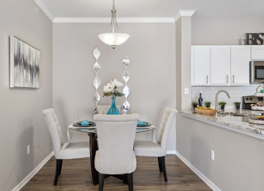a dining room with a table and chairs and a kitchen at Sonterra Apartment Homes, Austin, 78726