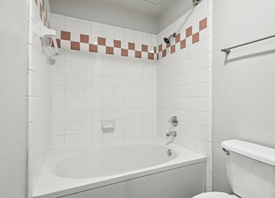 A white bathroom with a tub and toilet.