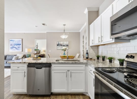 a kitchen with white cabinets and a counter top at Sonterra Apartment Homes, Austin, 78726