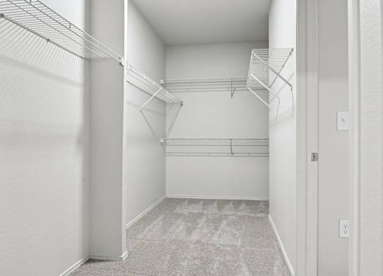 A white hallway with a carpeted floor and a door on the right.
