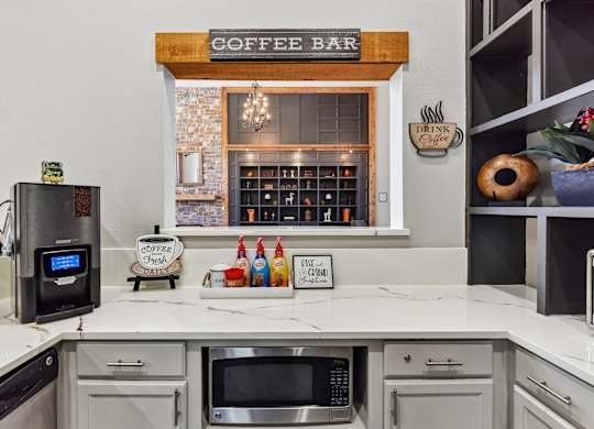 A coffee bar area with a coffee maker and a sign that says