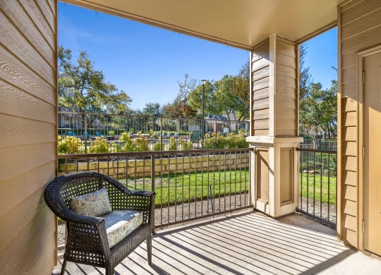 a balcony with a chair and a fence and a garden at Sonterra Apartment Homes, Austin, 78726