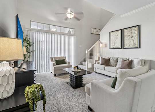 A living room with a white sofa and a grey carpet.