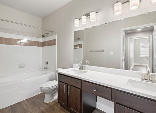 a bathroom with a large mirror and a sink and a toilet at The Verandah, Austin, TX