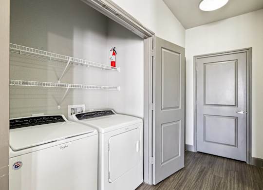 A laundry room with a washer and dryer and a door.at North Creek, Texas, 78634