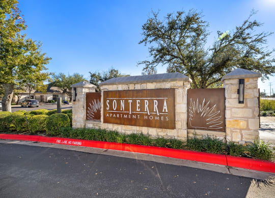 a sign apartment homes in front of a street at Sonterra Apartment Homes, Austin