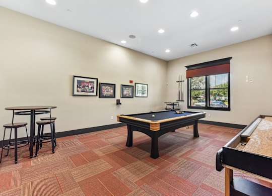A room with a pool table and a bar.