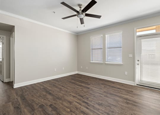 an empty living room with a ceiling fan and window at The Verandah, Texas