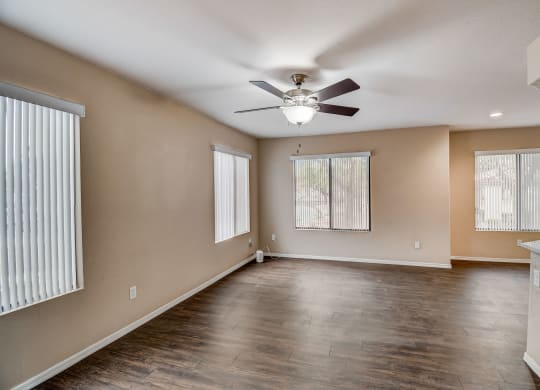 an empty living room with a ceiling fan and a window  at San Montego Apartments, Mesa, Arizona