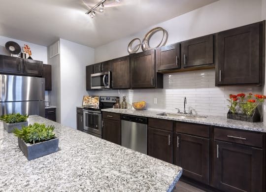 a kitchen with stainless steel appliances and granite counter tops at North Creek, Hutto