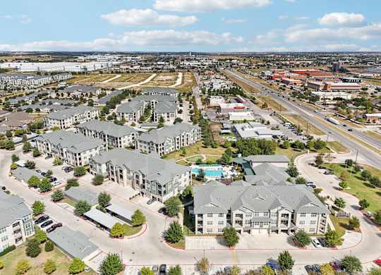 A bird's eye view of a residential area with multiple houses and a swimming pool.at North Creek, Texas