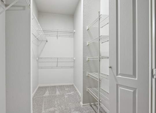 A white hallway with a carpeted floor and a door on the right.