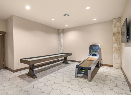 a game room with a shuffleboard table and a bench at Lakeline East Apartments, Texas, 78613